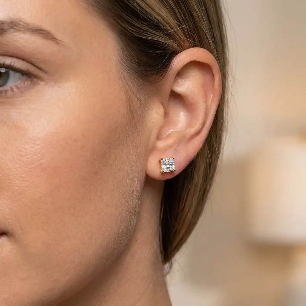 Woman wearing princess cut lab grown diamond stud earrings 14K gold screw back elegant square studs