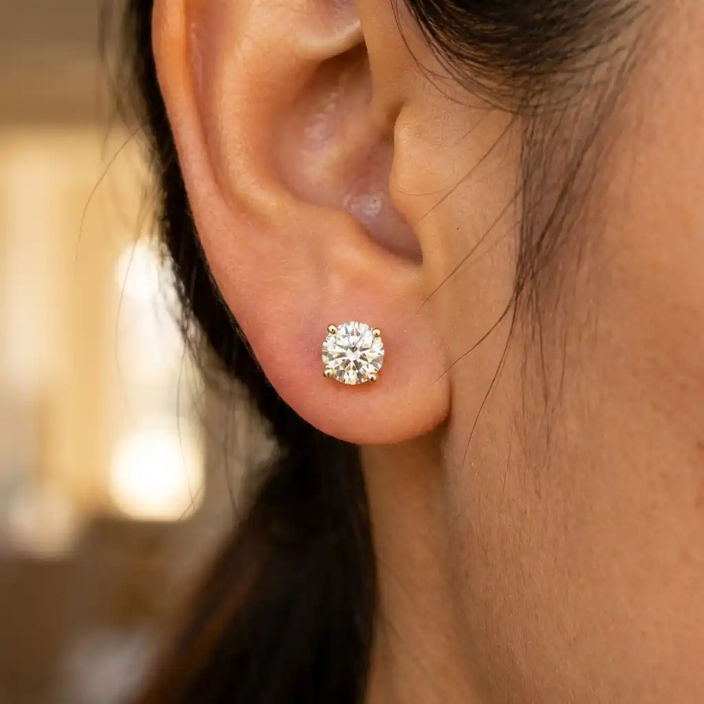 Woman wearing lab grown diamond stud earrings 14K gold premium round diamond studs elegant look