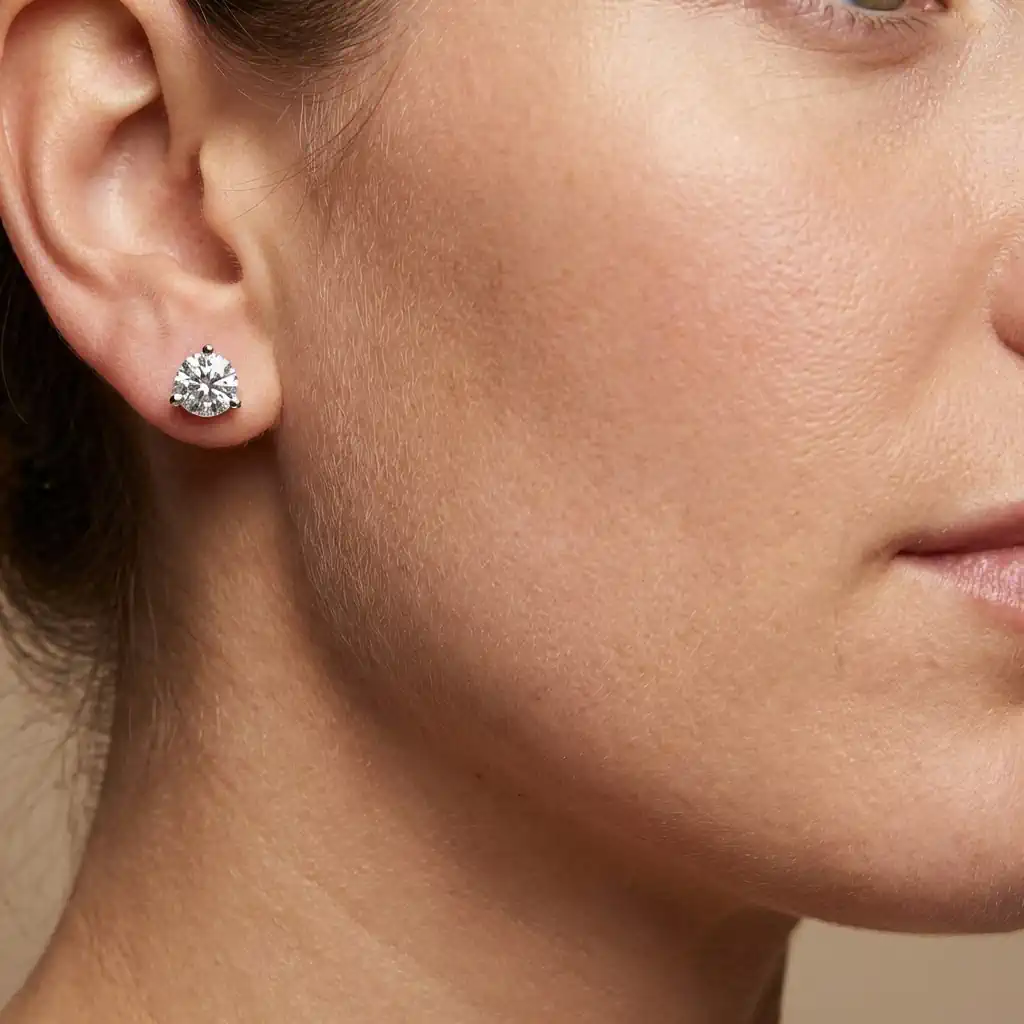 Woman wearing round lab grown diamond stud earrings 14K white gold 3 prong martini